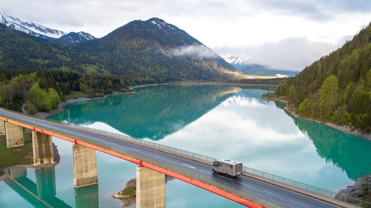 Wohnmobil auf Brücke vor See